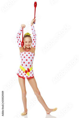 A girl gymnast performs exercises with a mace.