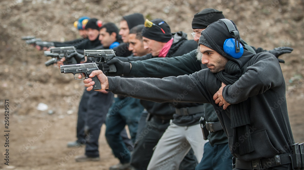 Group of civilian practice gun shooting on outdoor shooting range Group of civilian practice gun shooting on outdoor shooting range