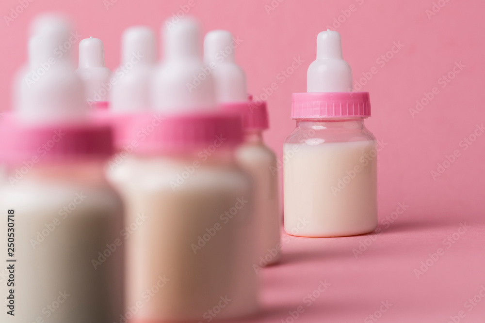 Baby bottle full of milk on a pink background Baby bottle full of milk on a pink background