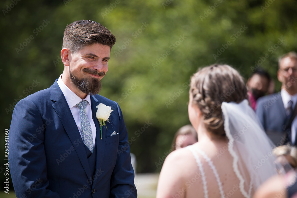 Happy couple looking at each other while standing in wedding ceremony Happy couple looking at each other while standing in wedding ceremony