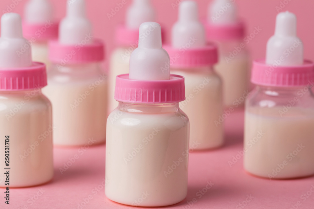 Baby bottle full of milk on a pink background Baby bottle full of milk on a pink background