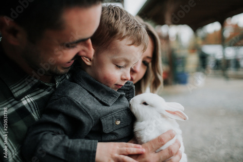Family playing with rabbit on farm photo