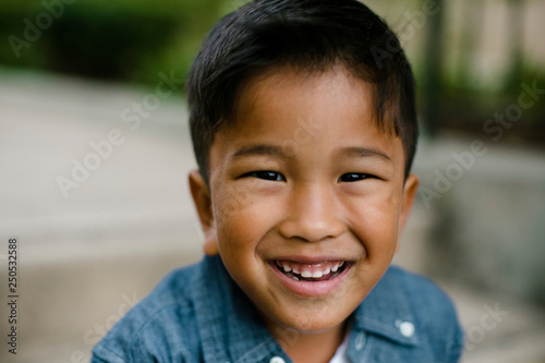Close-up portrait of cute happy boy sitting on steps at Balboa Park photo