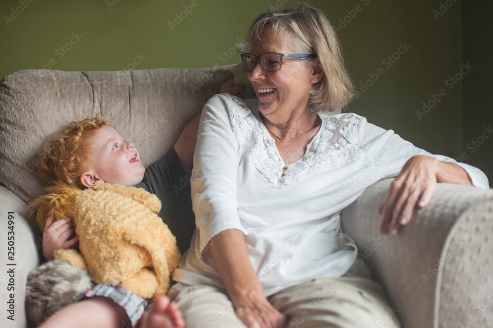Smiling grandmother and grandson sitting on armchair at home Smiling grandmother and grandson sitting on armchair at home
