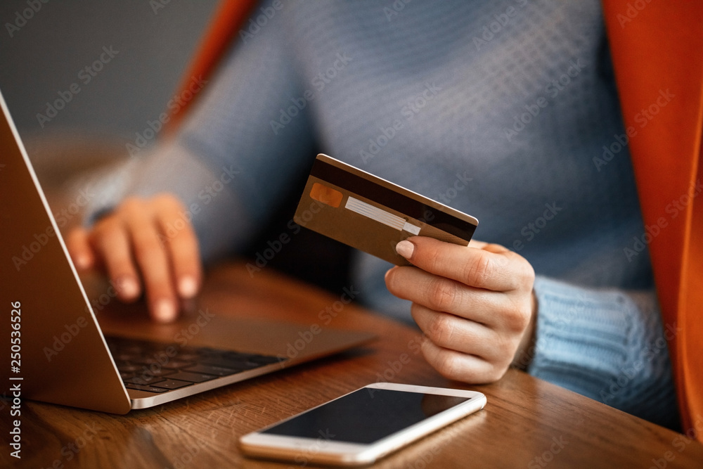 Unrecognizable woman using credit card and shopping online. Unrecognizable woman using credit card and shopping online.