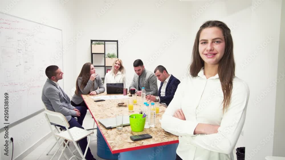 business woman portrait standing in front of her team, looking at camera business woman portrait standing in front of her team, looking at camera