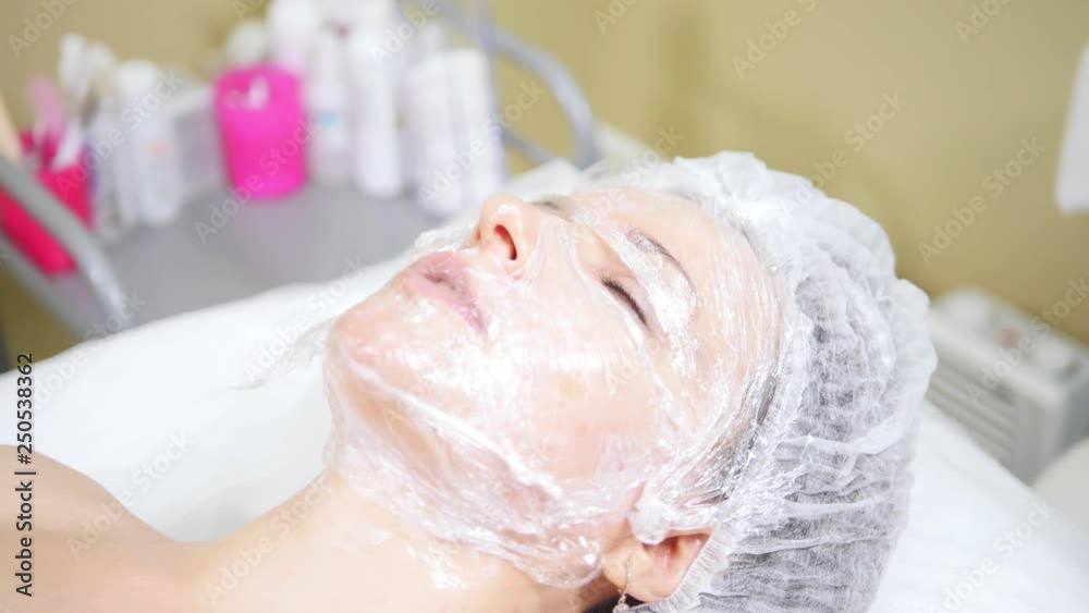 Woman with a mask on her face doing cosmetic procedures cleaning mesotherapy of the face in cosmetology clinic. Woman with a mask on her face doing cosmetic procedures cleaning mesotherapy of the face in cosmetology clinic.