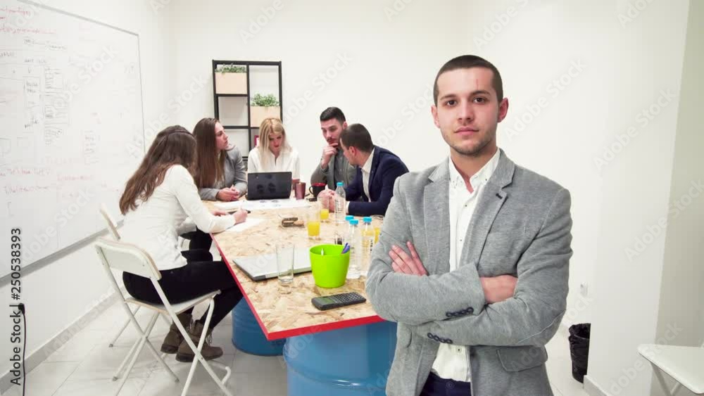 business man portrait standing in front of his team, looking at camera business man portrait standing in front of his team, looking at camera