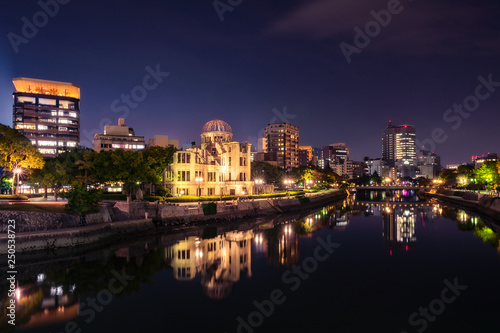 Hiroshima Skyline by night on the side of Motoyasu river in Japan with the Atomic Bomb Dome, the historic remains of the atomic blast.