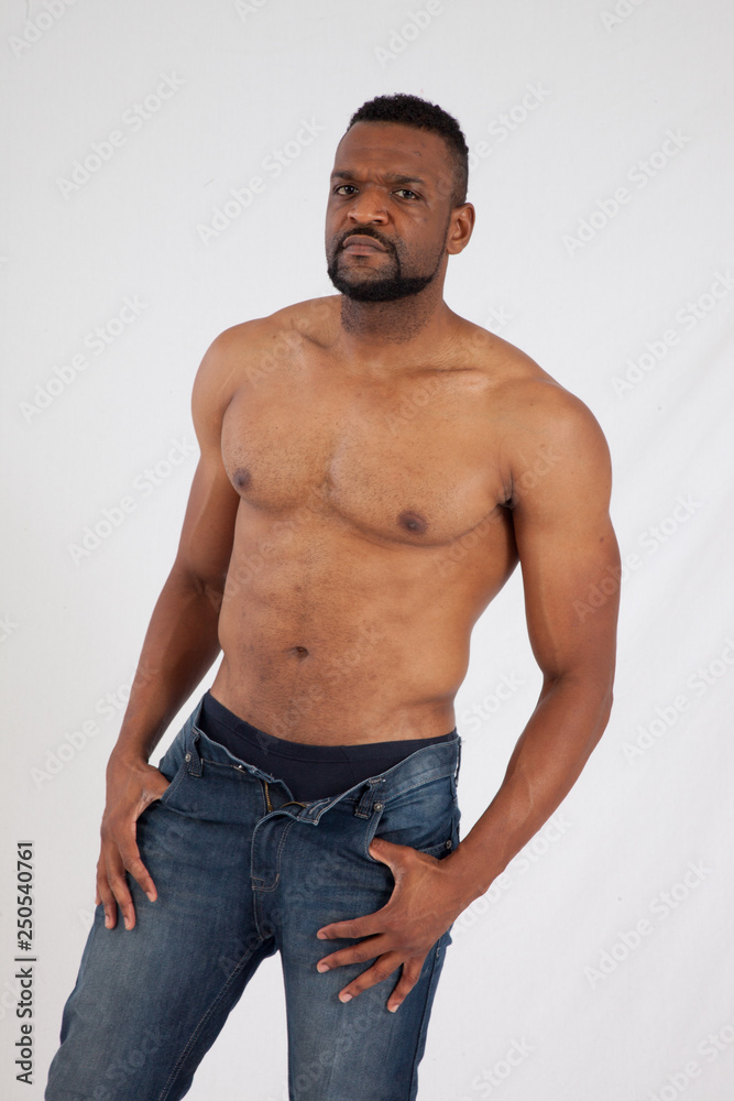 Strong Black man with his shirt off and looking serious