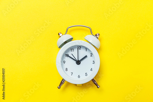 Ringing twin bell vintage classic alarm clock Isolated on yellow colourful trendy modern background. Rest hours time of life good morning night wake up awake concept. Flat lay top view copy space