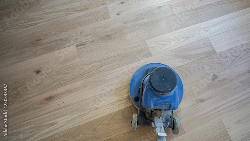 Renovieren von Parkett mit Einscheibenmaschine, polieren, Reinigen oder schleifen von Fußboden.