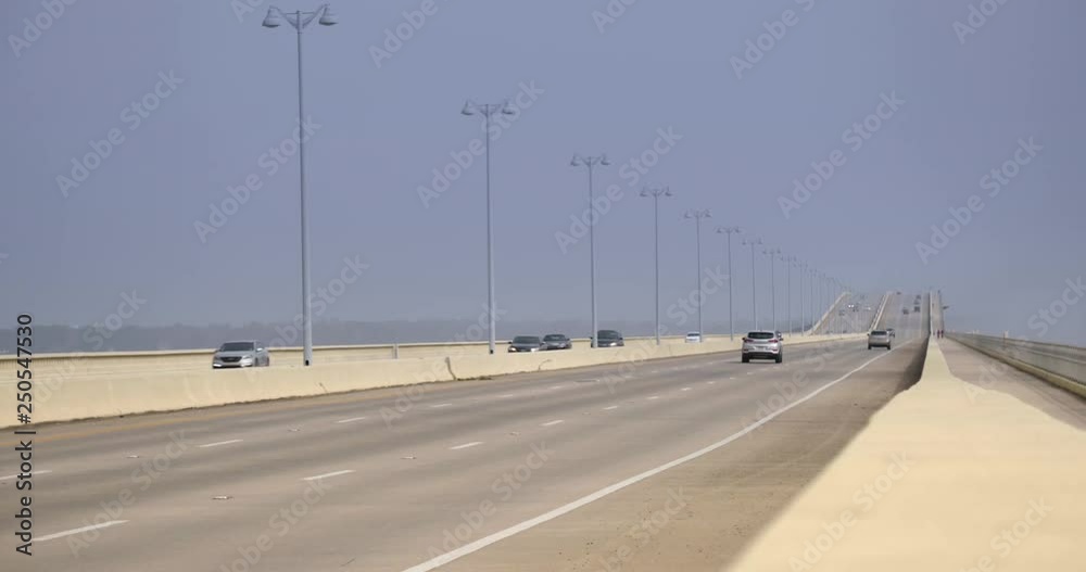 A long shot view of traffic traveling on the Biloxi Bay Bridge on a foggy day.  	