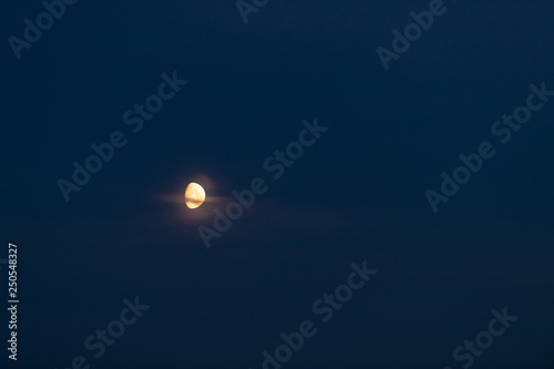 Landscape view of moon crescent rising above Laugarvatn lake on golden circle in Iceland during twilight purple blue dark colors