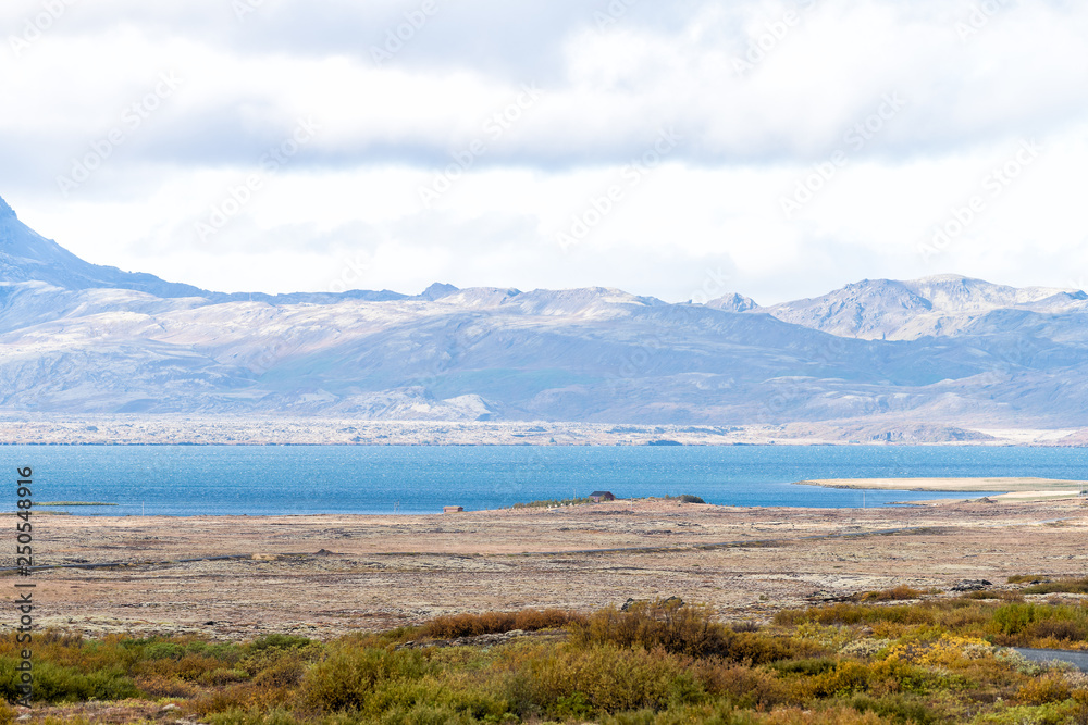 Landscape view of Thingvellir or Laugarvatn mountains and lake with clouds on golden circle in Iceland during day and blue color water in autumn Landscape view of Thingvellir or Laugarvatn mountains and lake with clouds on golden circle in Iceland during day and blue color water in autumn