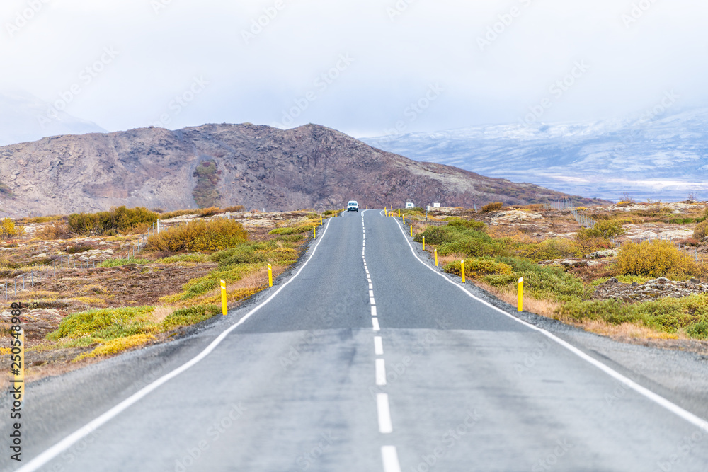 Landscape view of Thingvellir mountains with clouds covering on golden circle in Iceland during day and highway 37 or 365 in autumn with cars on road