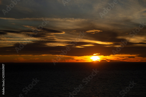 Dark Golden Sunset over Deep Blue Sean and Cloudy Sky