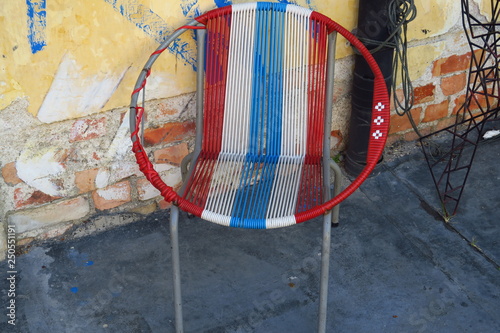 Vieux fauteuil rond tressage bleu blanc rouge