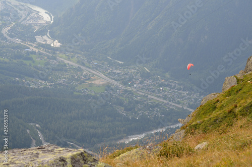 paraglider in alps over valley town