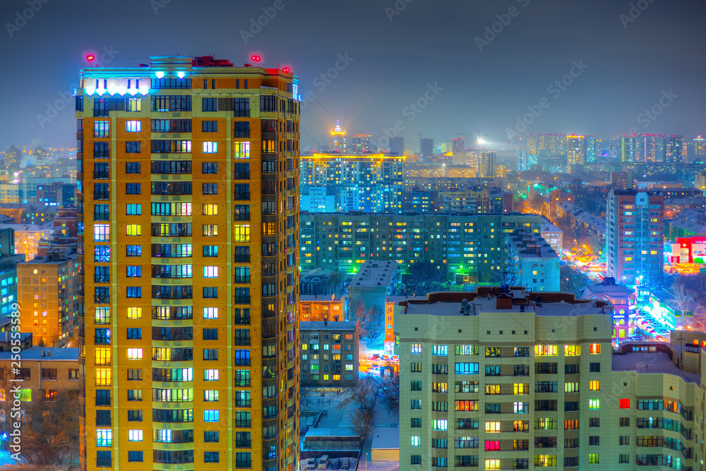 Obraz premium Beautiful top view of the city. Colorful street lighting of the night metropolis. Many high-rise buildings. Cold winter weather. There is snow on the roofs of houses. Novosibirsk, Siberia, Russia.