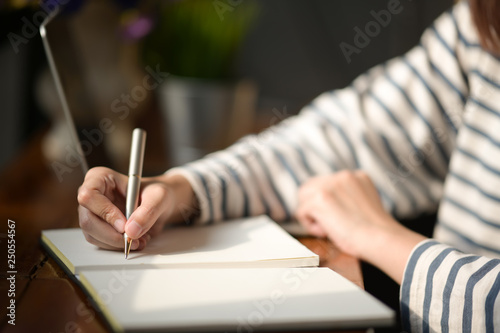 Woman hand writing on notebook
