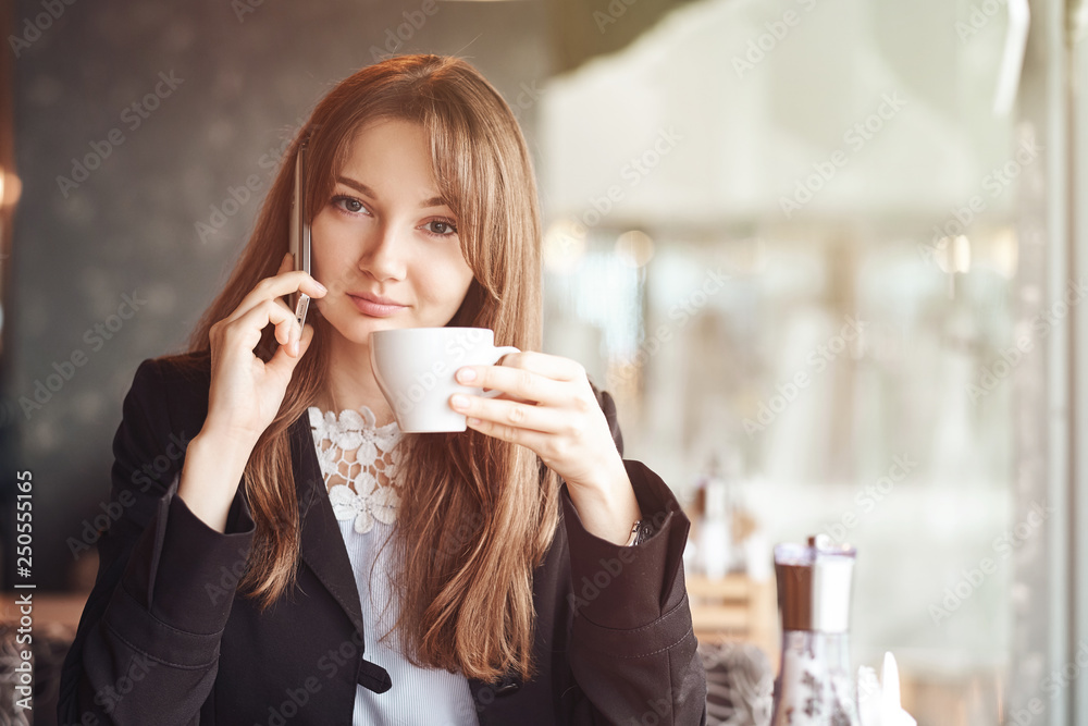 Young business woman talking on the phone in coffee shop Young business woman talking on the phone in coffee shop