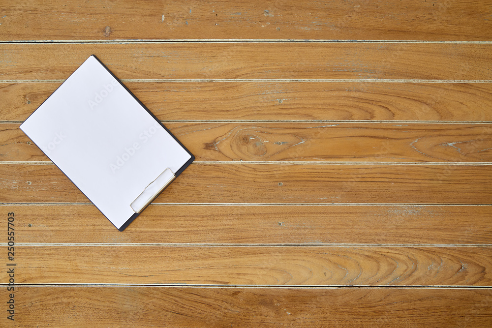 Clipboard with white sheet on wooden background Clipboard with white sheet on wooden background