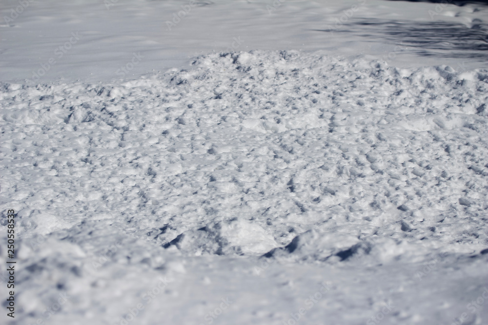 Close-up view of snow textures featured in deep banks of shoveled snow