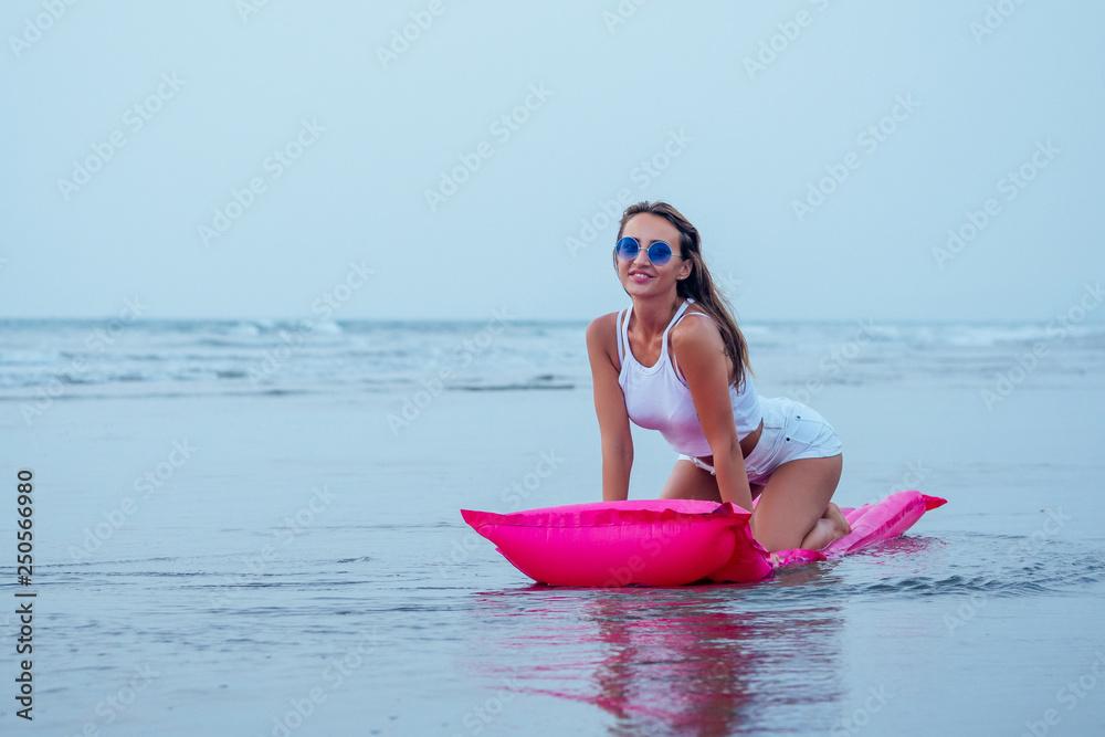 Young pretty fashion woman body posing in summer with mattress in black bikini and having fun