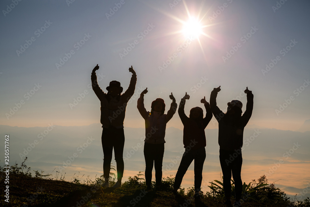 Silhouette group of young woman having fun outdoors; sunrise