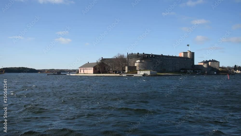 Early spring view over the harbour in Vaxholm with ferries and a fortress island Early spring view over the harbour in Vaxholm with ferries and a fortress island