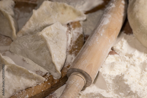 piece of dough, flour and rolling pin on the table