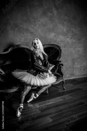 Ballerina girl in black tights white tutu and leather jacket. Concept of dance and body, ballet dancer 