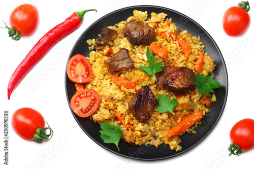 pilaf with meat and chili pepper on black plate isolated on white background. top view