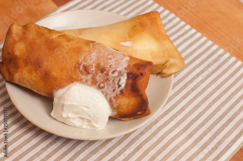 crepes on a plate with sour cream photo