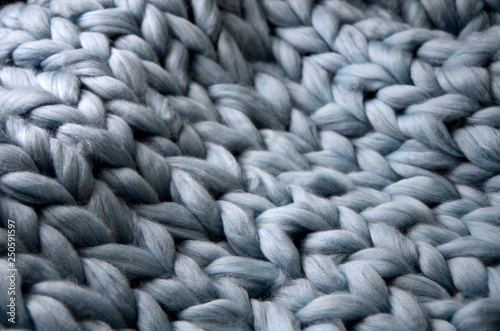 Merino wool handmade knitted large blanket, super chunky yarn, trendy concept. Close-up of knitted blanket, merino wool background