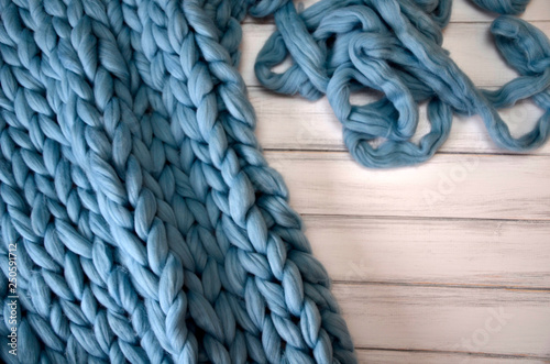 Merino wool handmade knitted large blanket, super chunky yarn, trendy concept. Close-up of knitted blanket, merino wool background