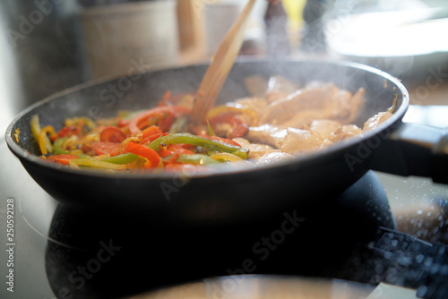 Closeup of frying pan with meat and vegetables being cooked