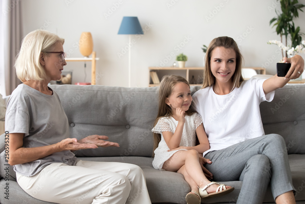 Grandmother displeased by mother with daughter making selfie