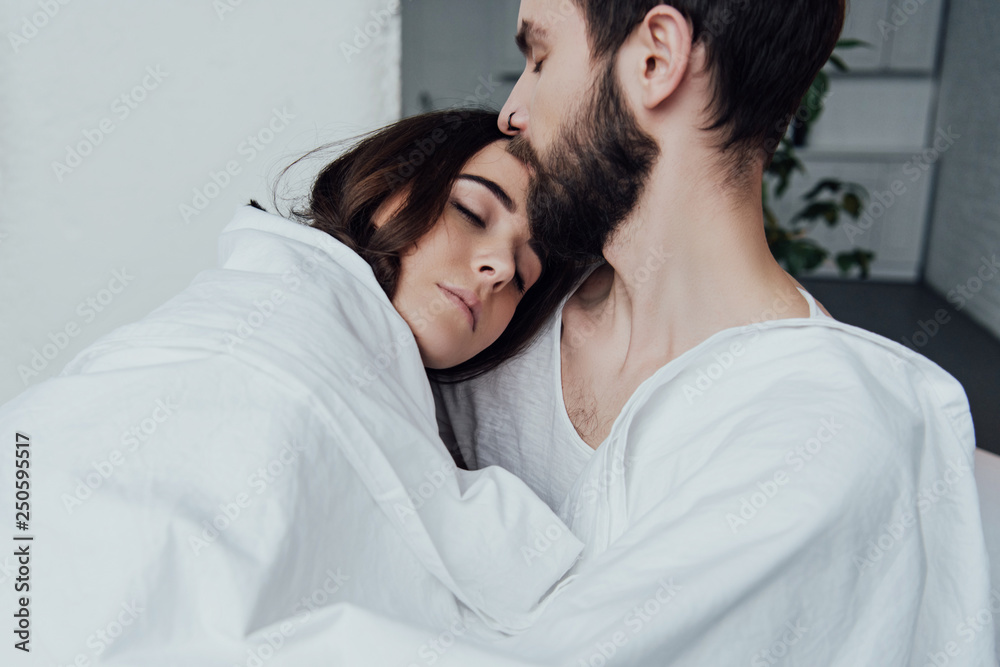 beautiful young couple sleeping in bed at home