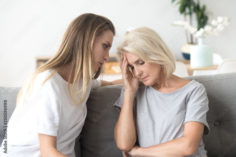 Loving daughter comforting, consoling aged upset mother at home Loving daughter comforting, consoling aged upset mother at home