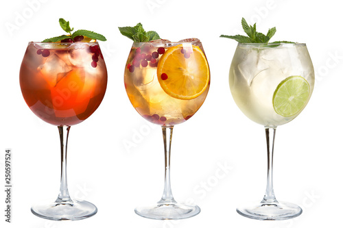 Refreshing cocktails with mint, fruits and berries on a white background. Set of three cocktails in glass goblets.