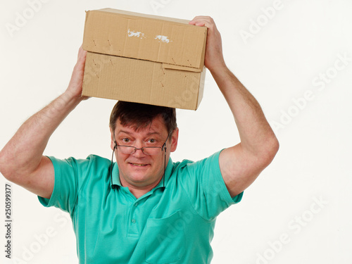 man holds in his hands a big box on a white background.