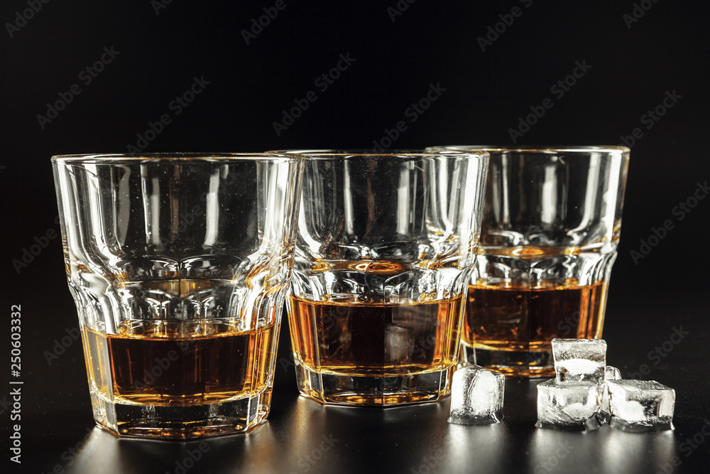 Whiskey and ice on rustic wood background Whiskey and ice on rustic wood background