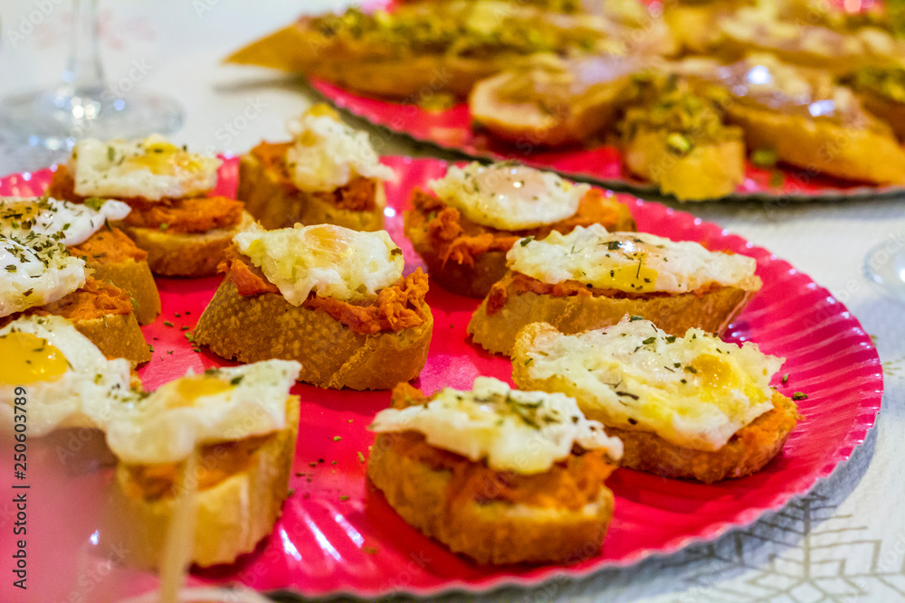 Typical spanish tapas, sobrasada sausage and fried quail eggs over a slice of bread Typical spanish tapas, sobrasada sausage and fried quail eggs over a slice of bread