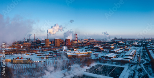 Concept of environmental pollution, drone view of smokestack pipe steel plant, aerial industrial panoramic landscape with blue sky in winter evening, air emissions from manufacturing sector,Russia