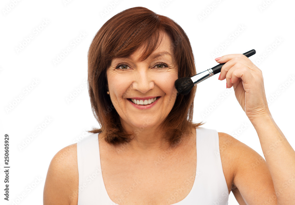 Fototapeta premium beauty, make up and old people concept - smiling senior woman with blush brush over white background