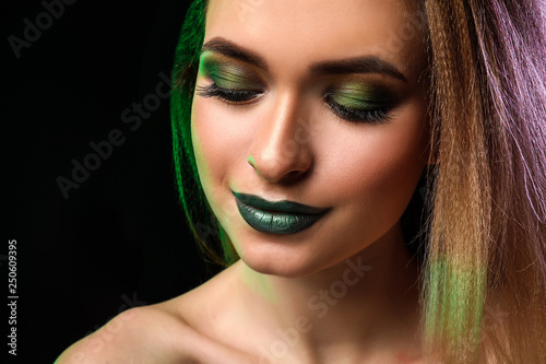 Beautiful young woman with bright makeup on dark background