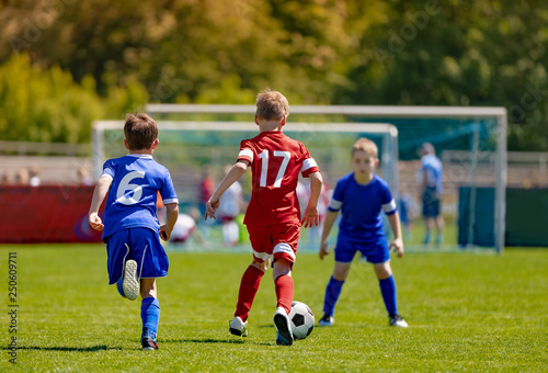 Boys Football Soccer Players Running with Ball. Soccer School Tournament Game © matimix