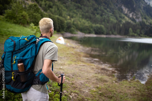 Young man traveling with backpack hiking in mountains
